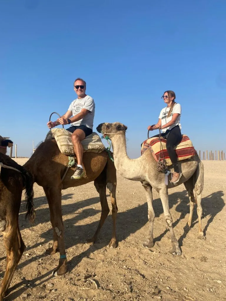 Travellers riding camels in the Agafay Desert