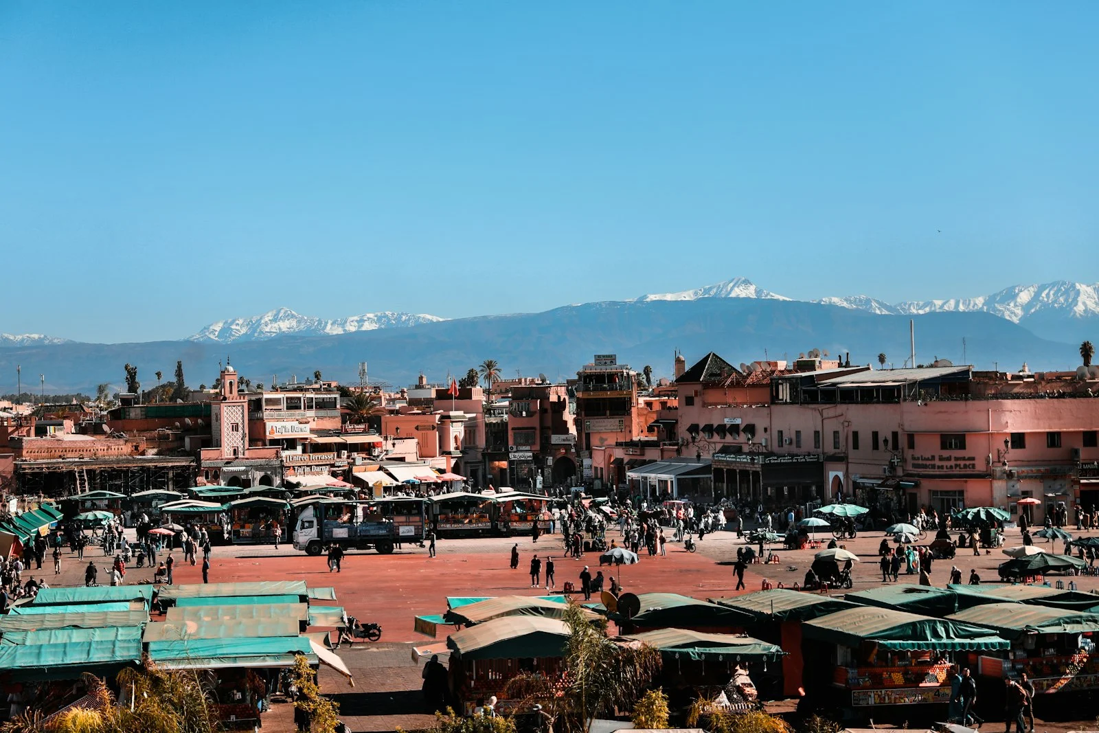 Place Jemaa el-Fna et les sommets enneigés du Haut Atlas Place Jemaa el-Fna et les sommets enneigés du Haut Atlas